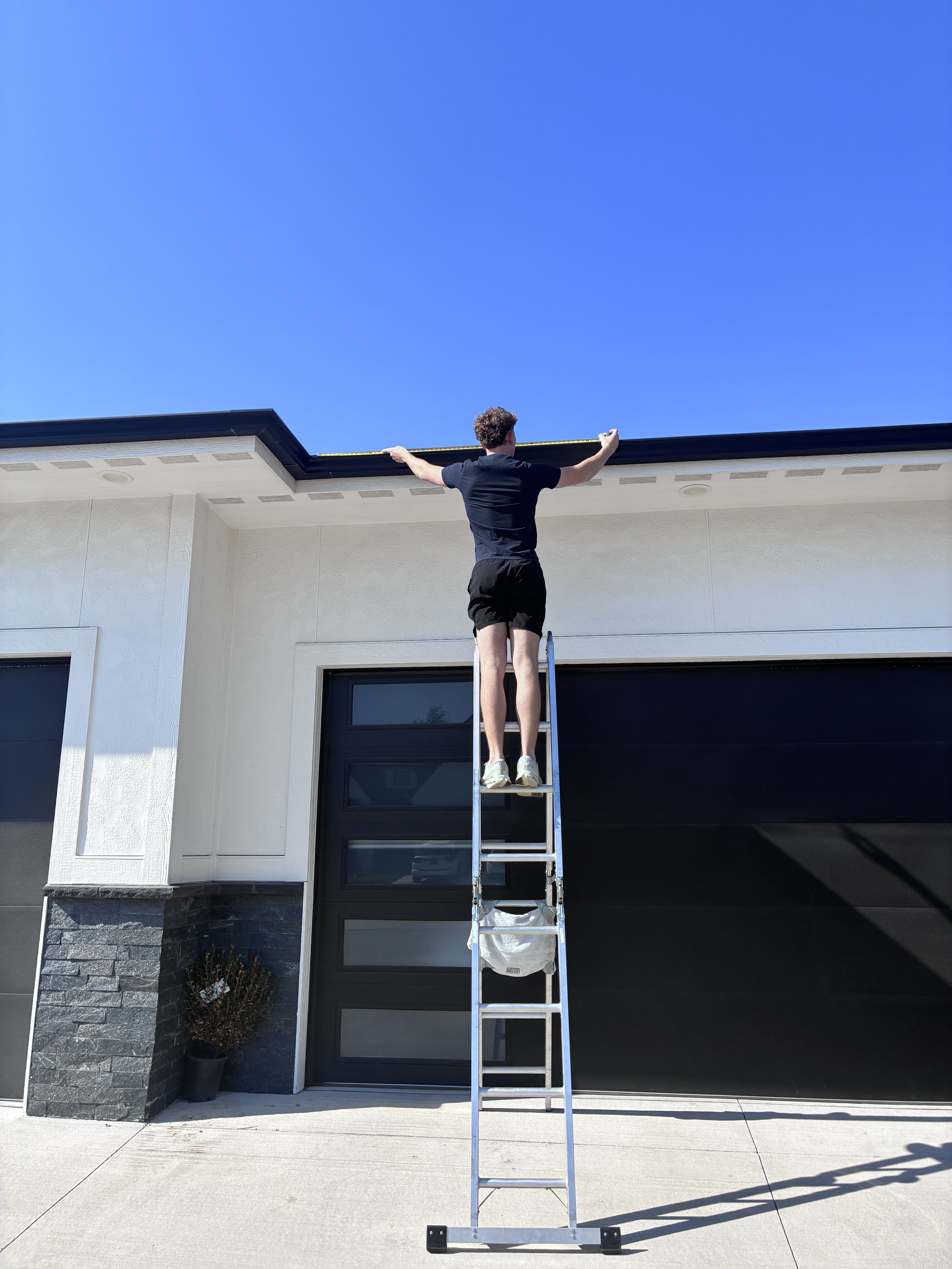 Installer on a ladder setting C9 bulbs with proper safety equipment