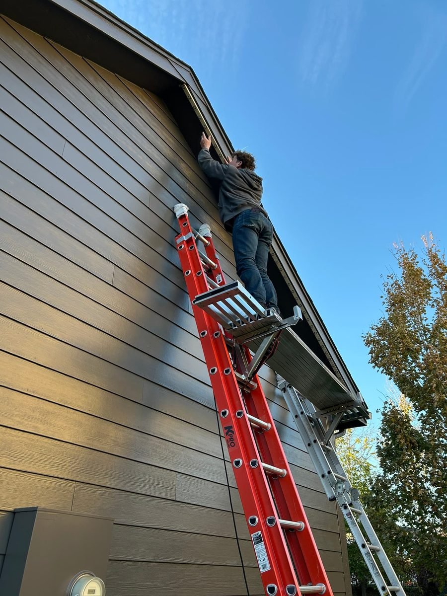 Warm white C9 bulbs clipped along the gutter line and up both sides of a front gable at night