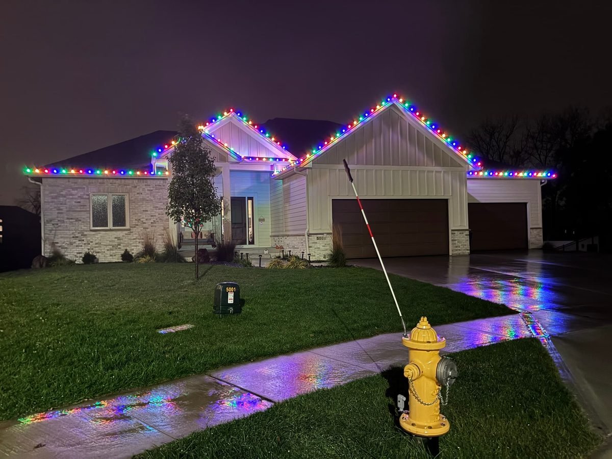 Multicolor C9 LED bulbs along the roofline and garage peak of a West Des Moines home