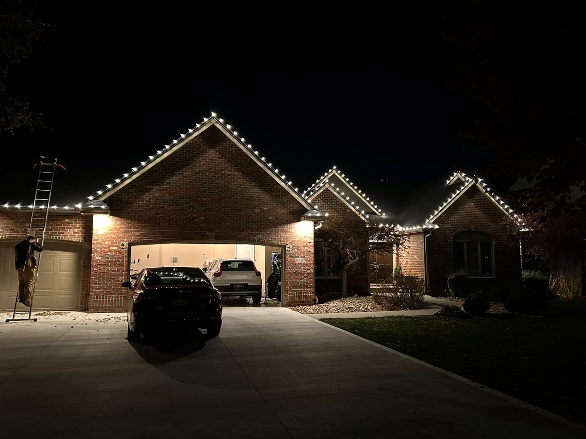 Close-up of warm white commercial-grade C9 bulbs clipped evenly along a gutter edge
